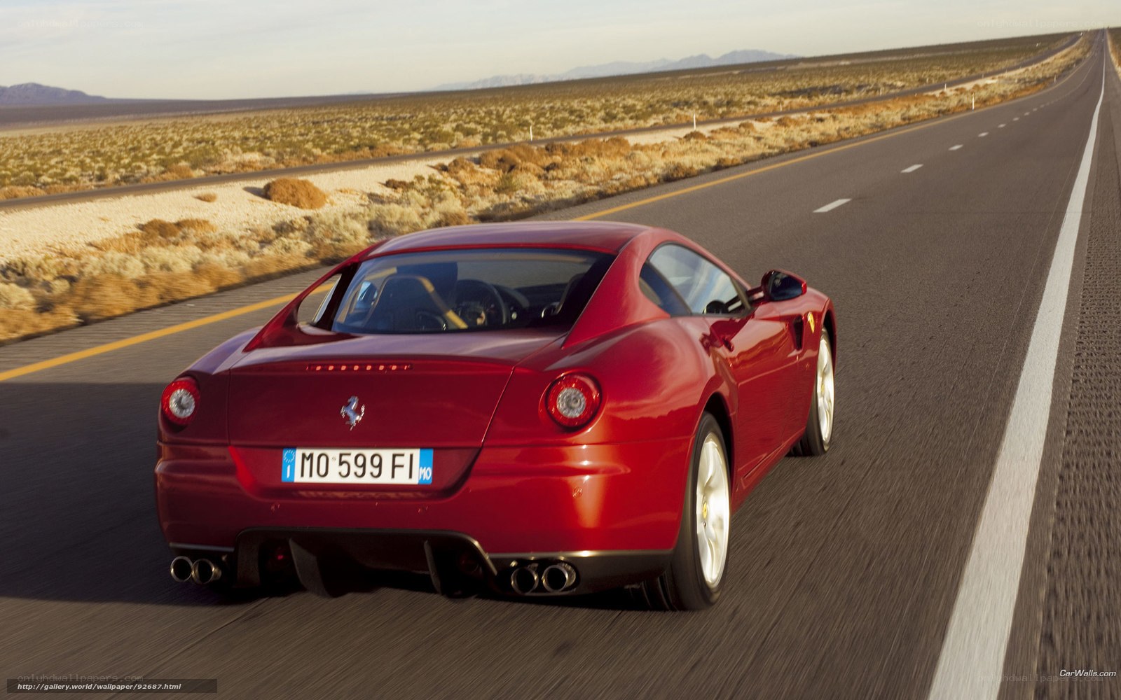 Red Ferrari driving on desert road