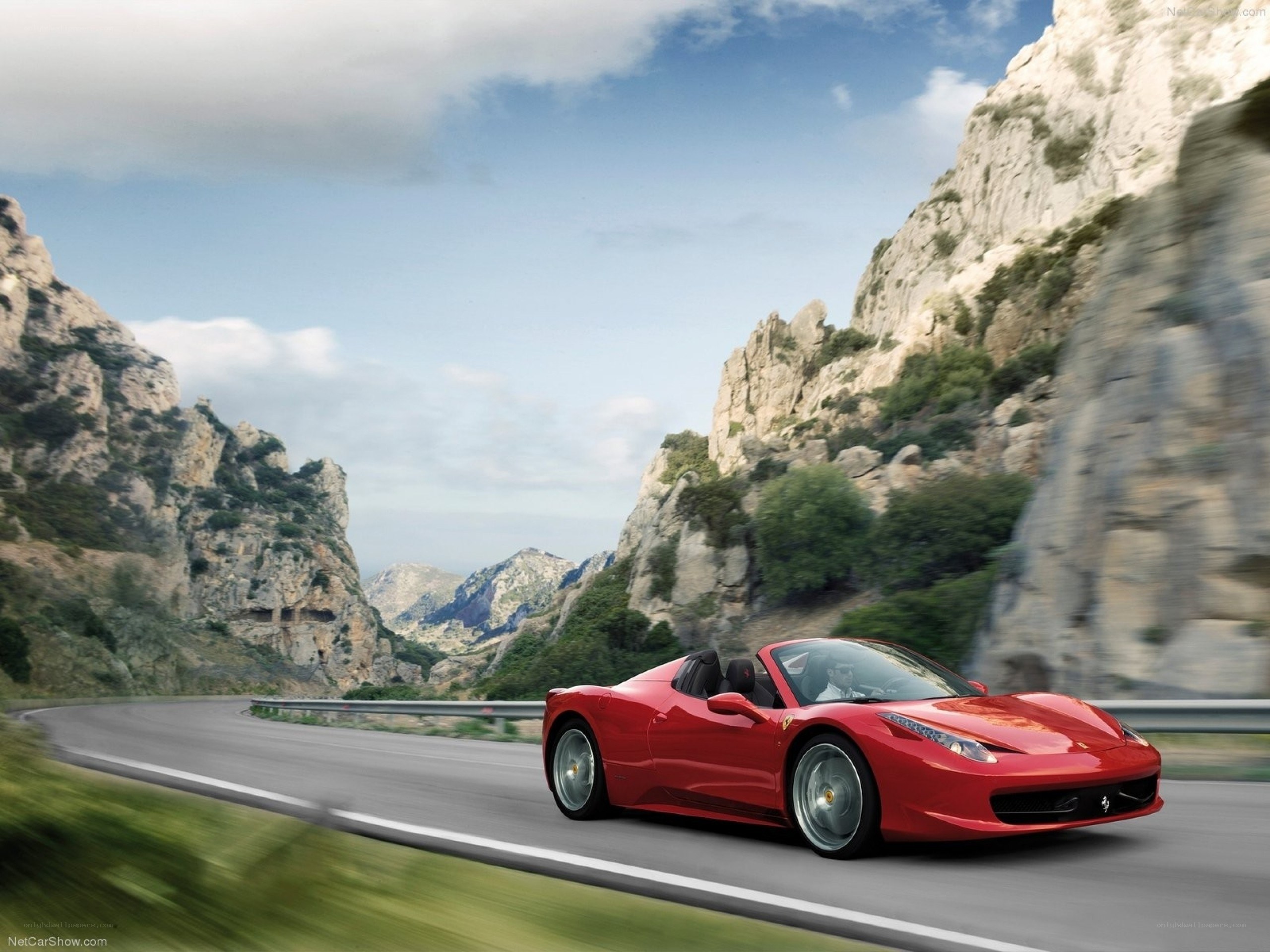 Red Ferrari driving on mountain road