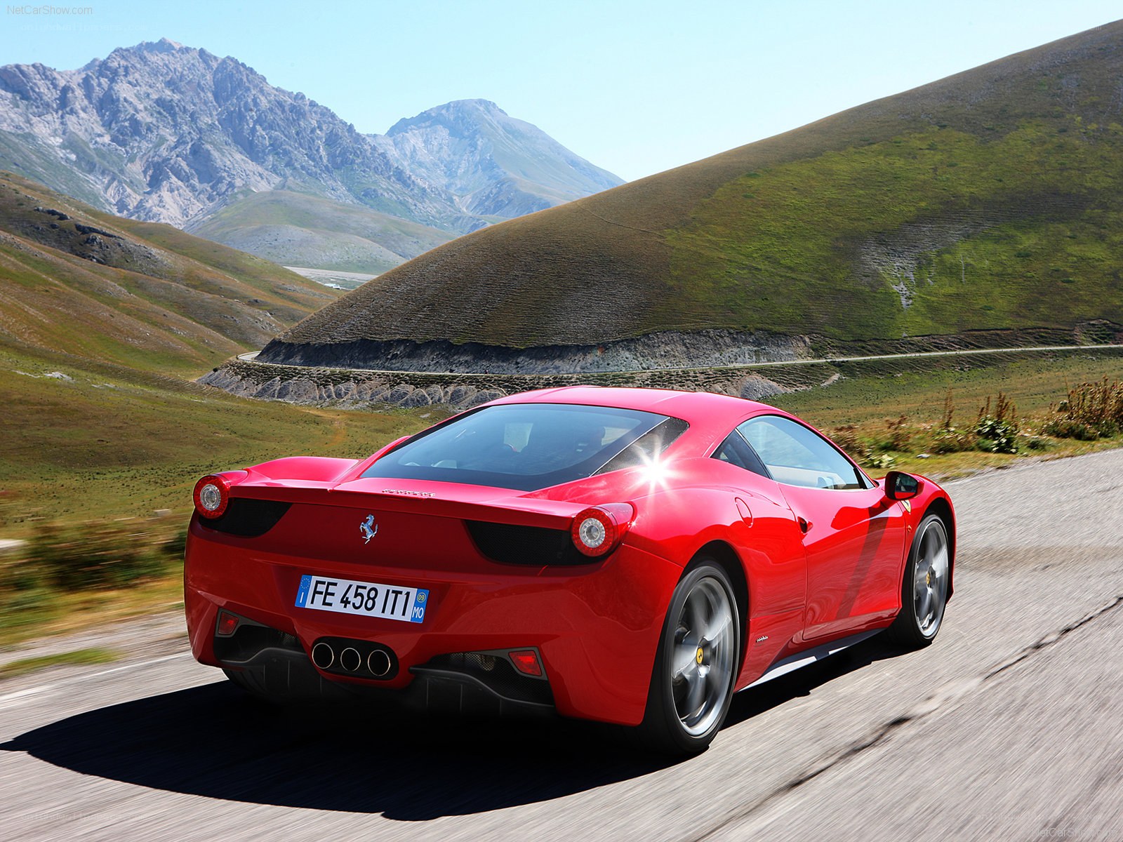 red ferrari driving on mountain road