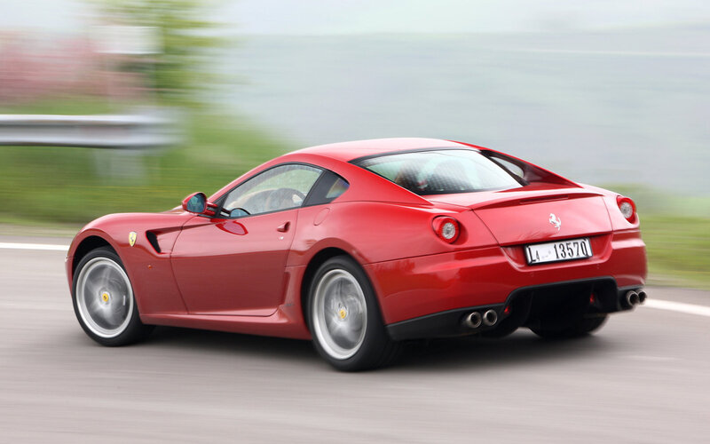 Red Ferrari driving on road