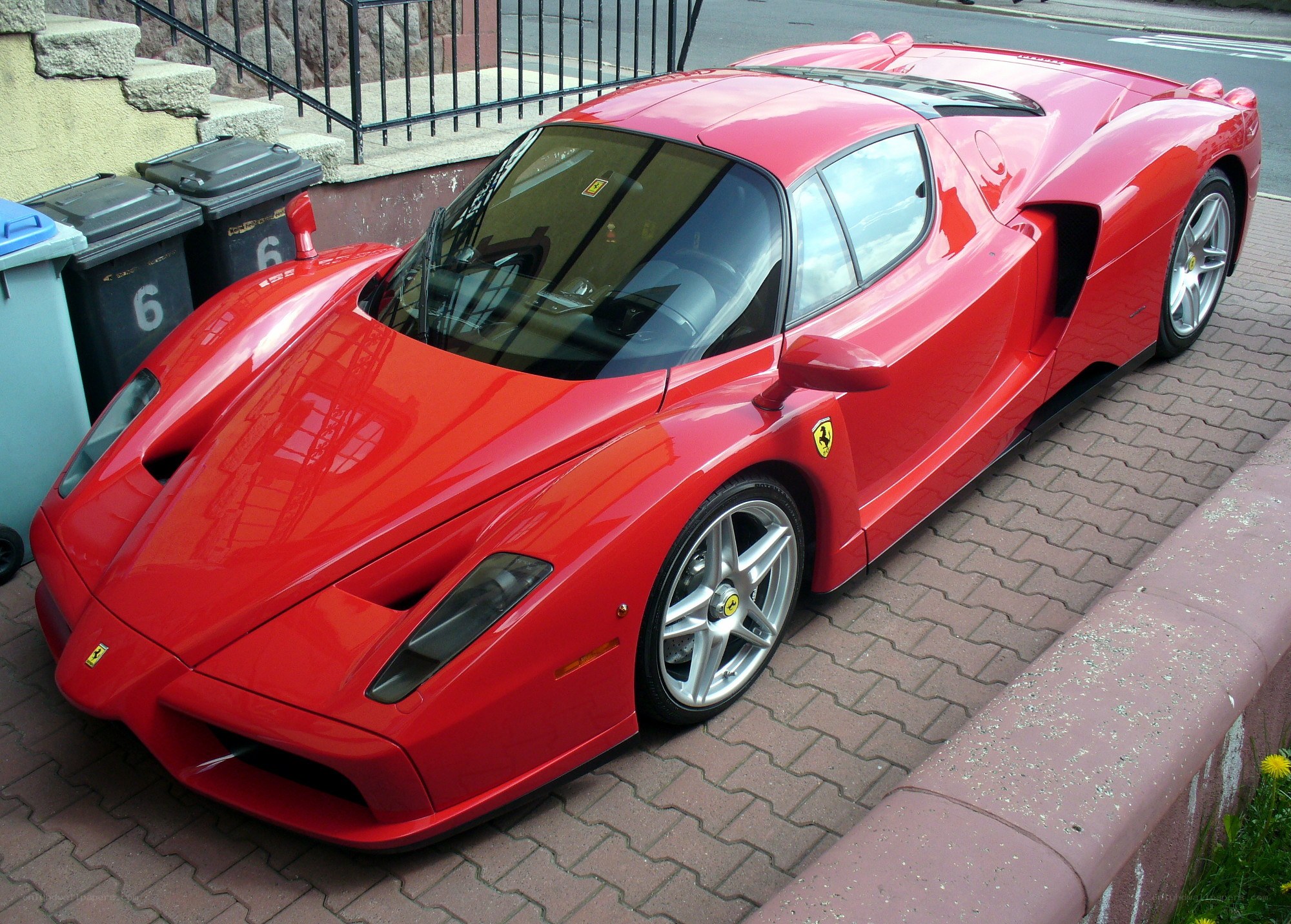 Red Ferrari Enzo parked on sidewalk