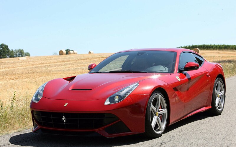 Red Ferrari F12berlinetta on country road