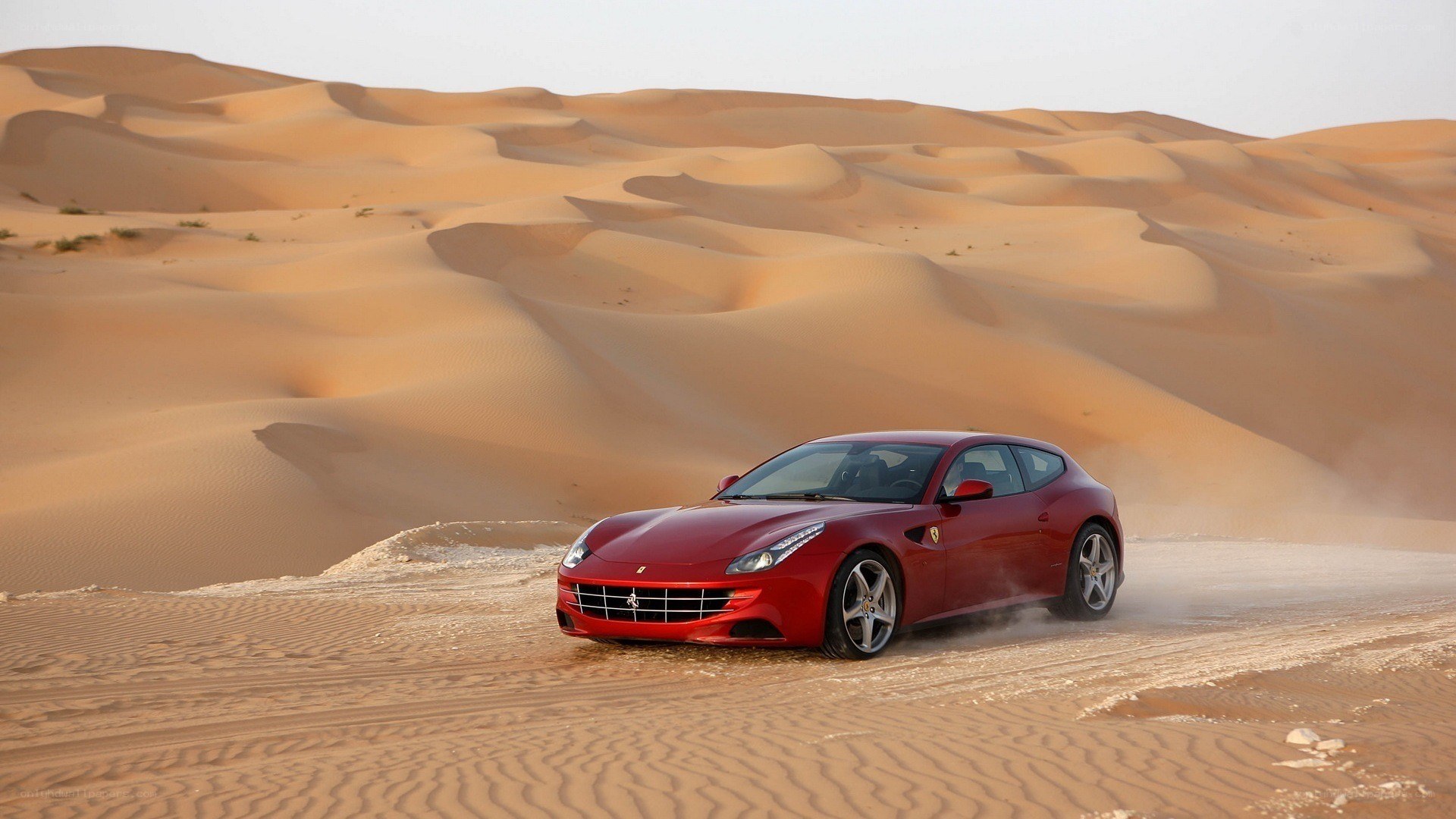 Red Ferrari in desert dunes