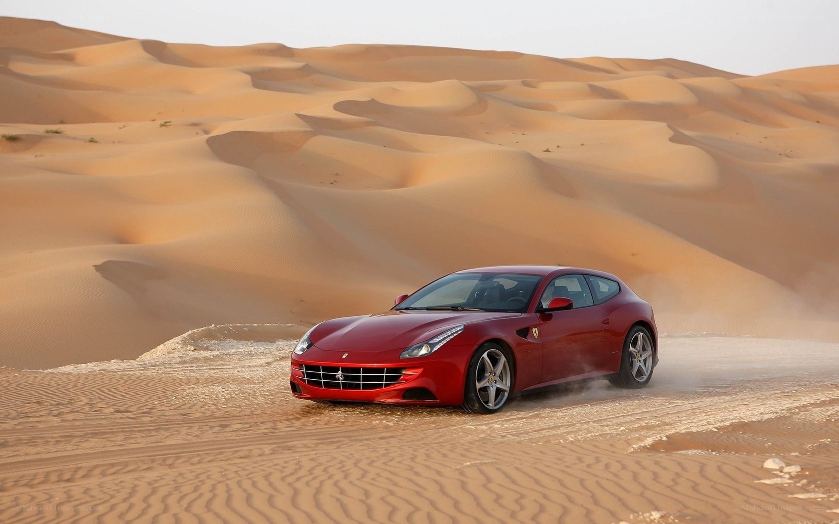 Red Ferrari in desert dunes