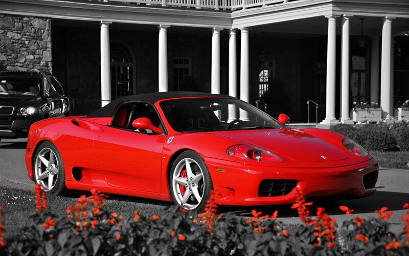 Red Ferrari in front of mansion