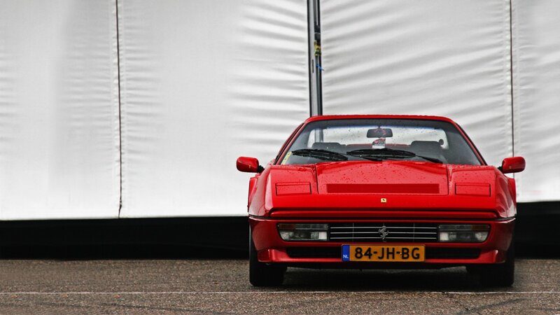 Red Ferrari in front of white tent