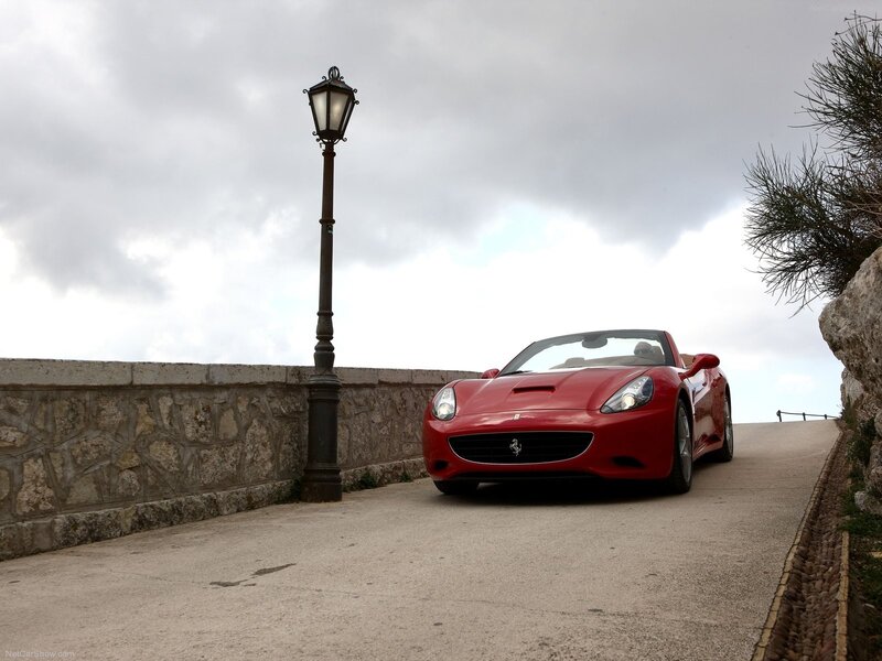 Red Ferrari on a coastal road