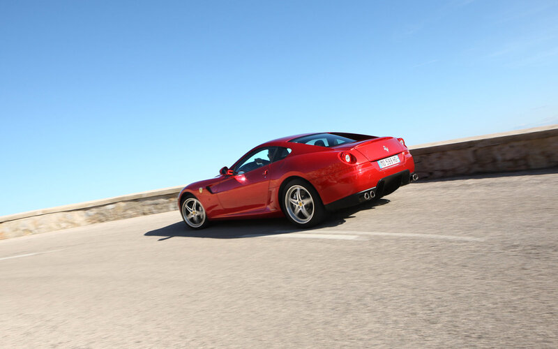 Red Ferrari on a coastal road
