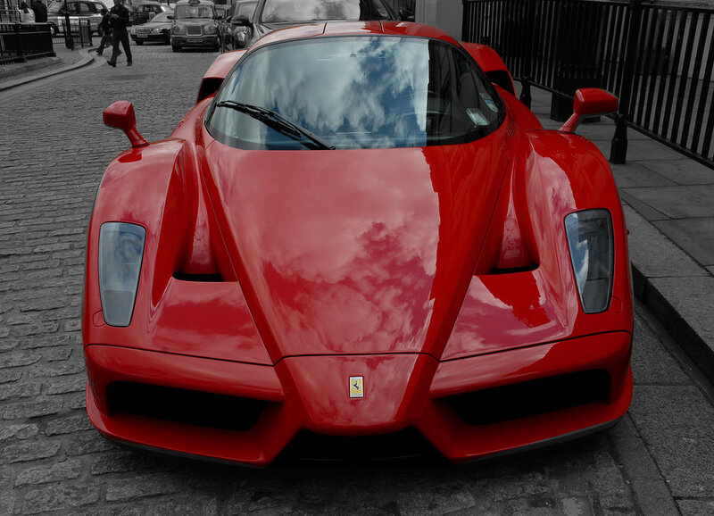 Red Ferrari on a cobblestone street
