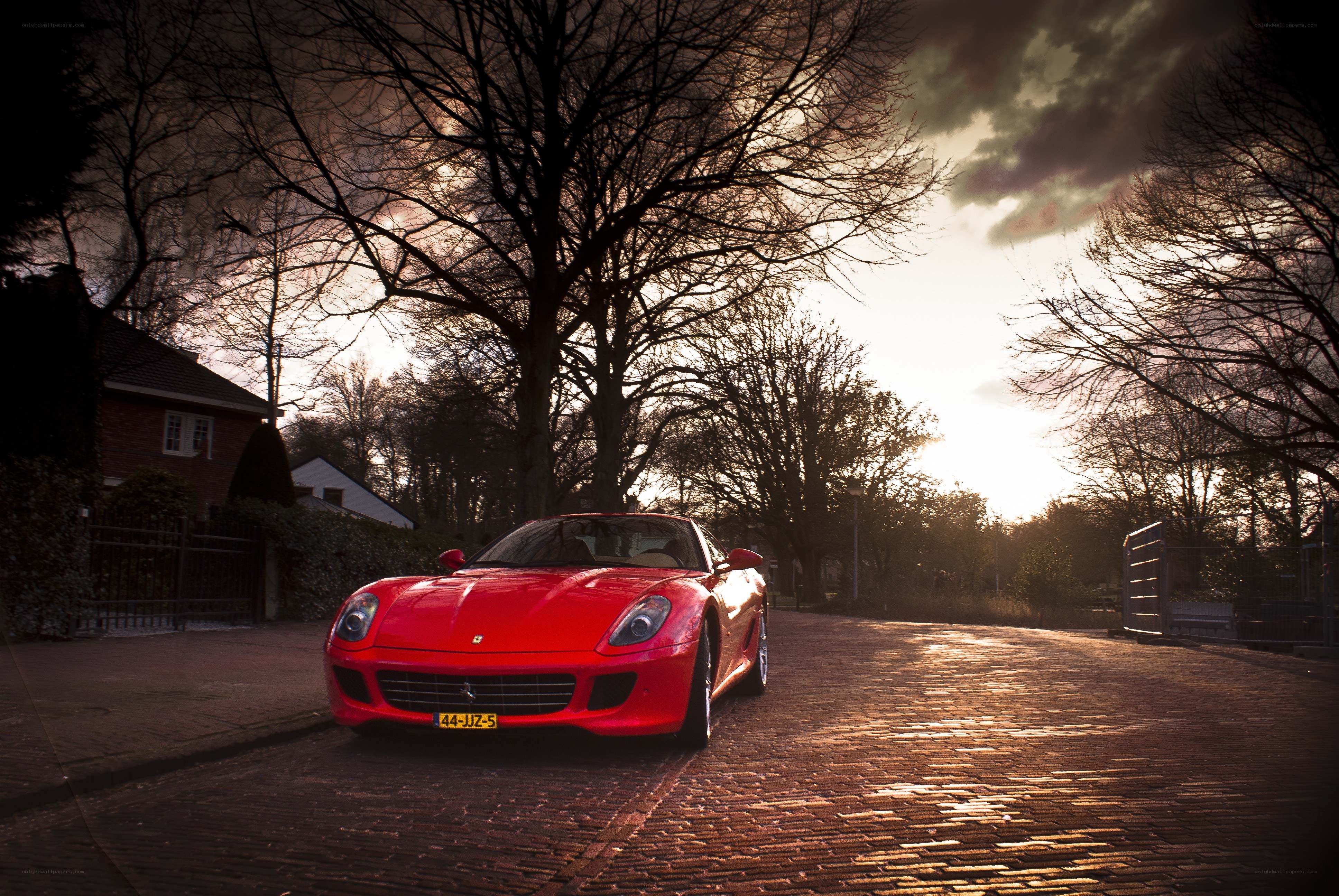 Red Ferrari on a cobblestone street