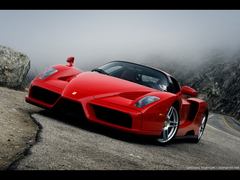 Red Ferrari on a foggy mountain road