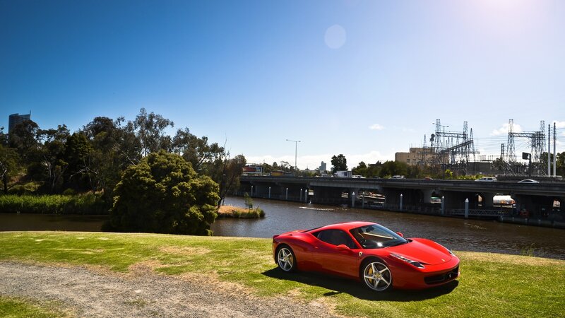 Red Ferrari on a grassy bank
