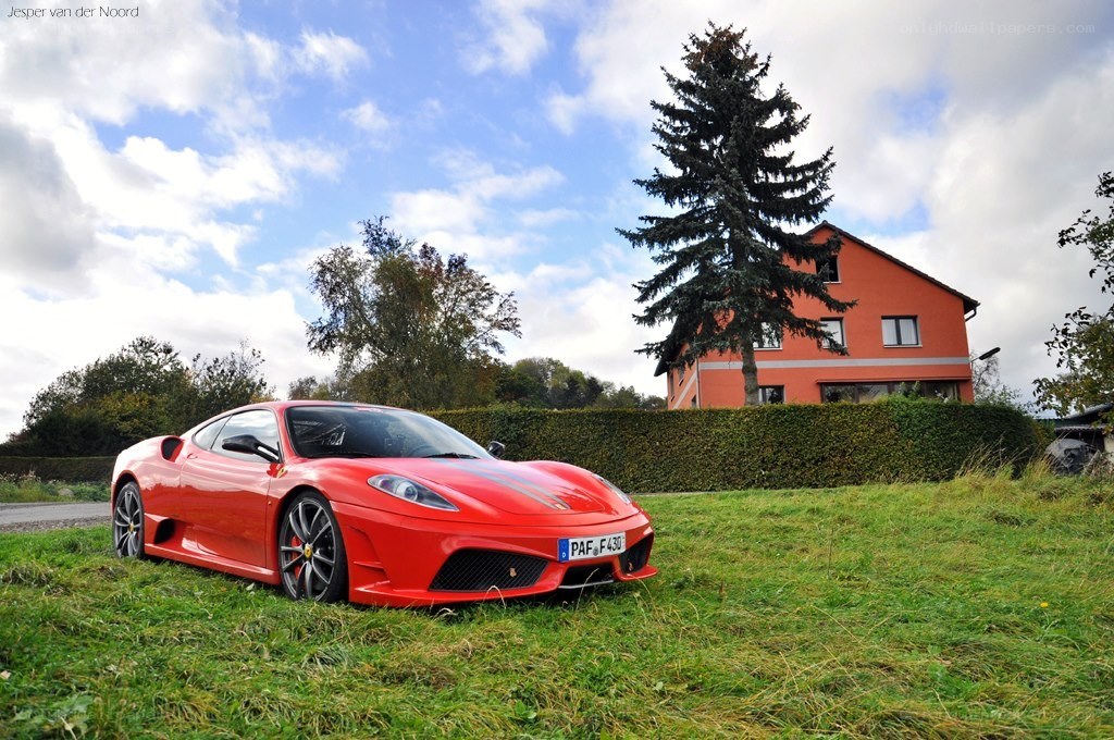 Red Ferrari on a grassy field