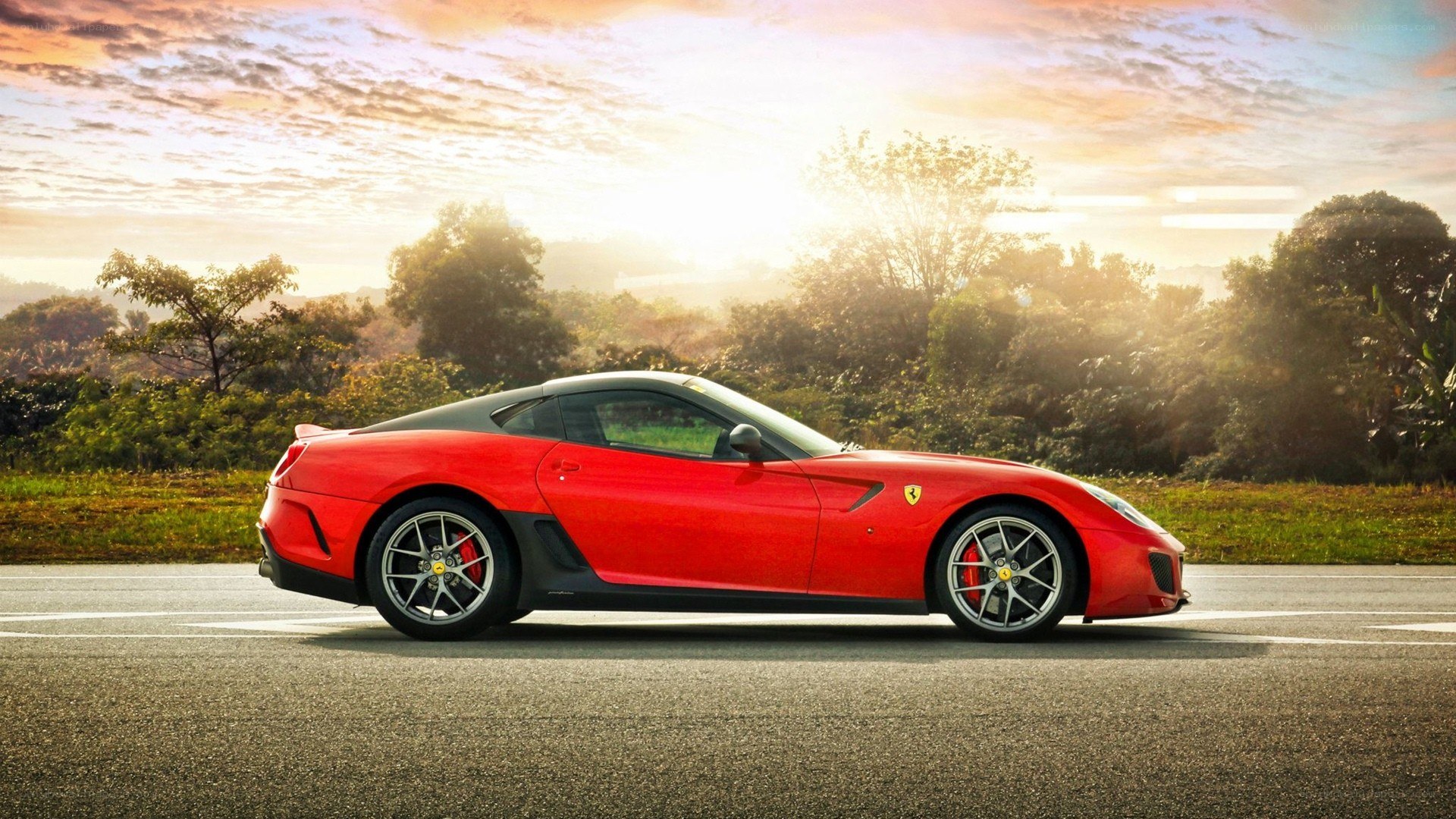 Red Ferrari on a road at sunset
