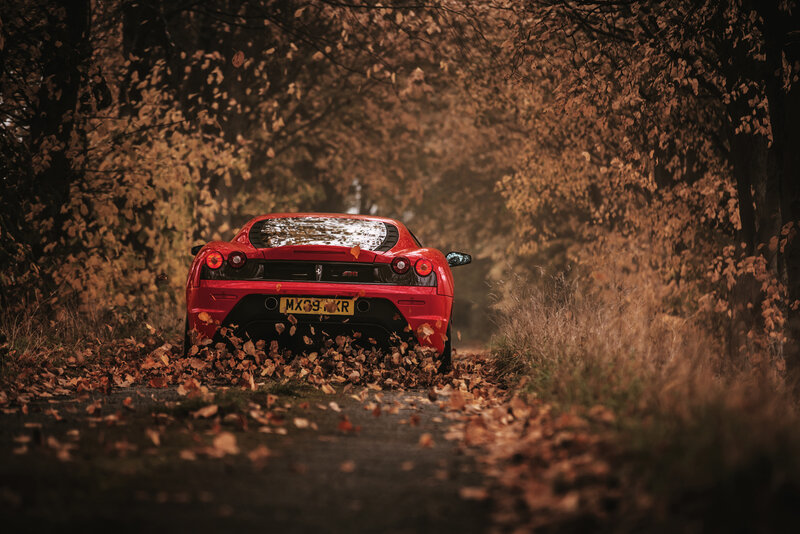 Red Ferrari on autumn road
