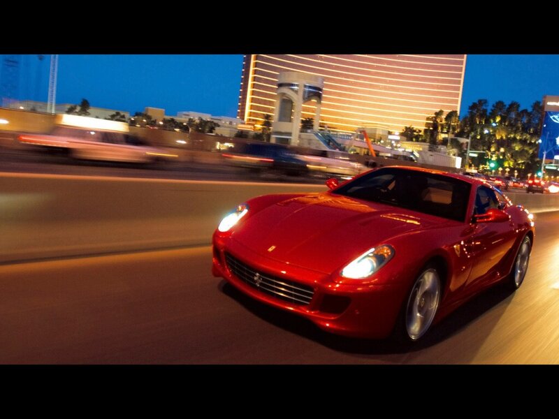 Red Ferrari on city street at night