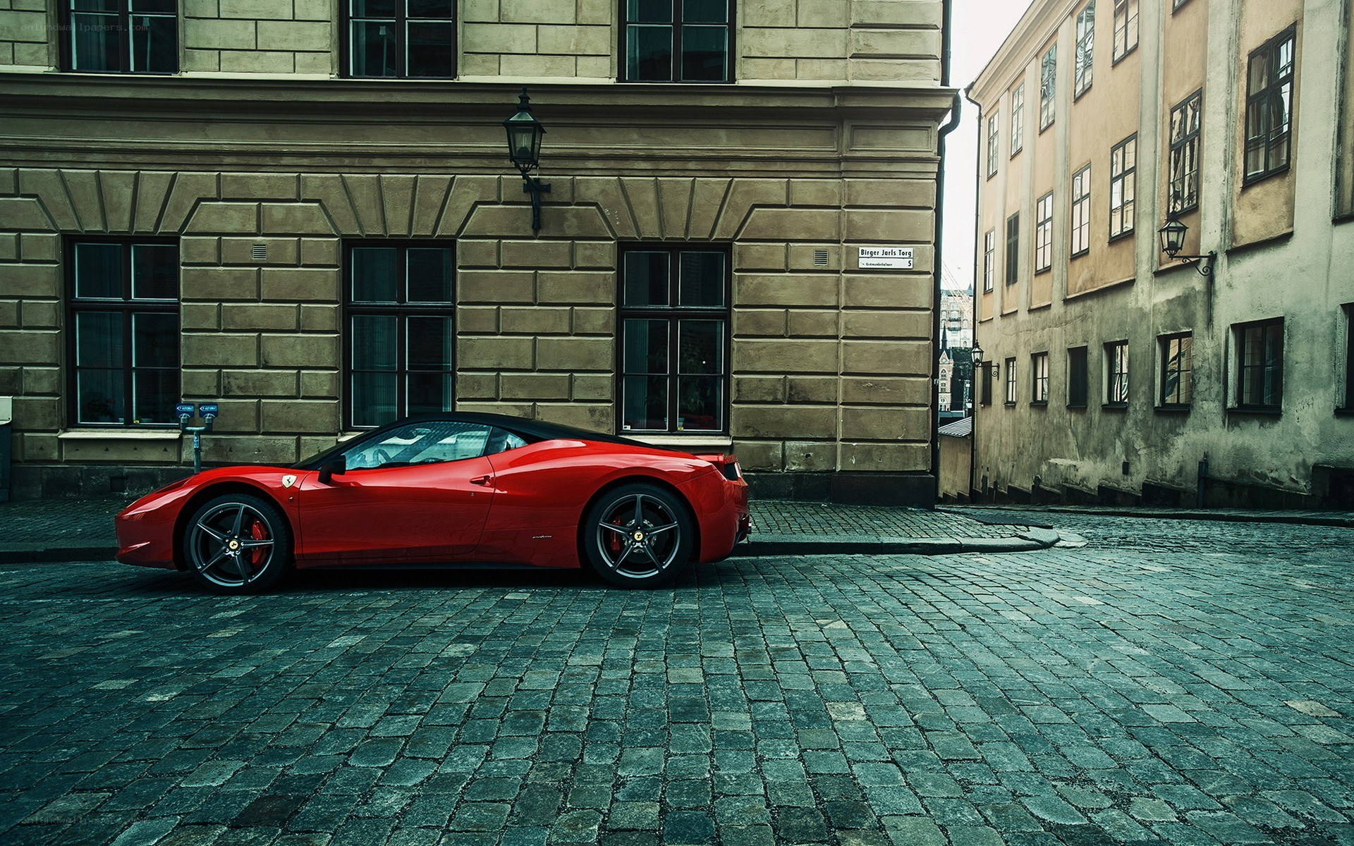 Red Ferrari on cobblestone street