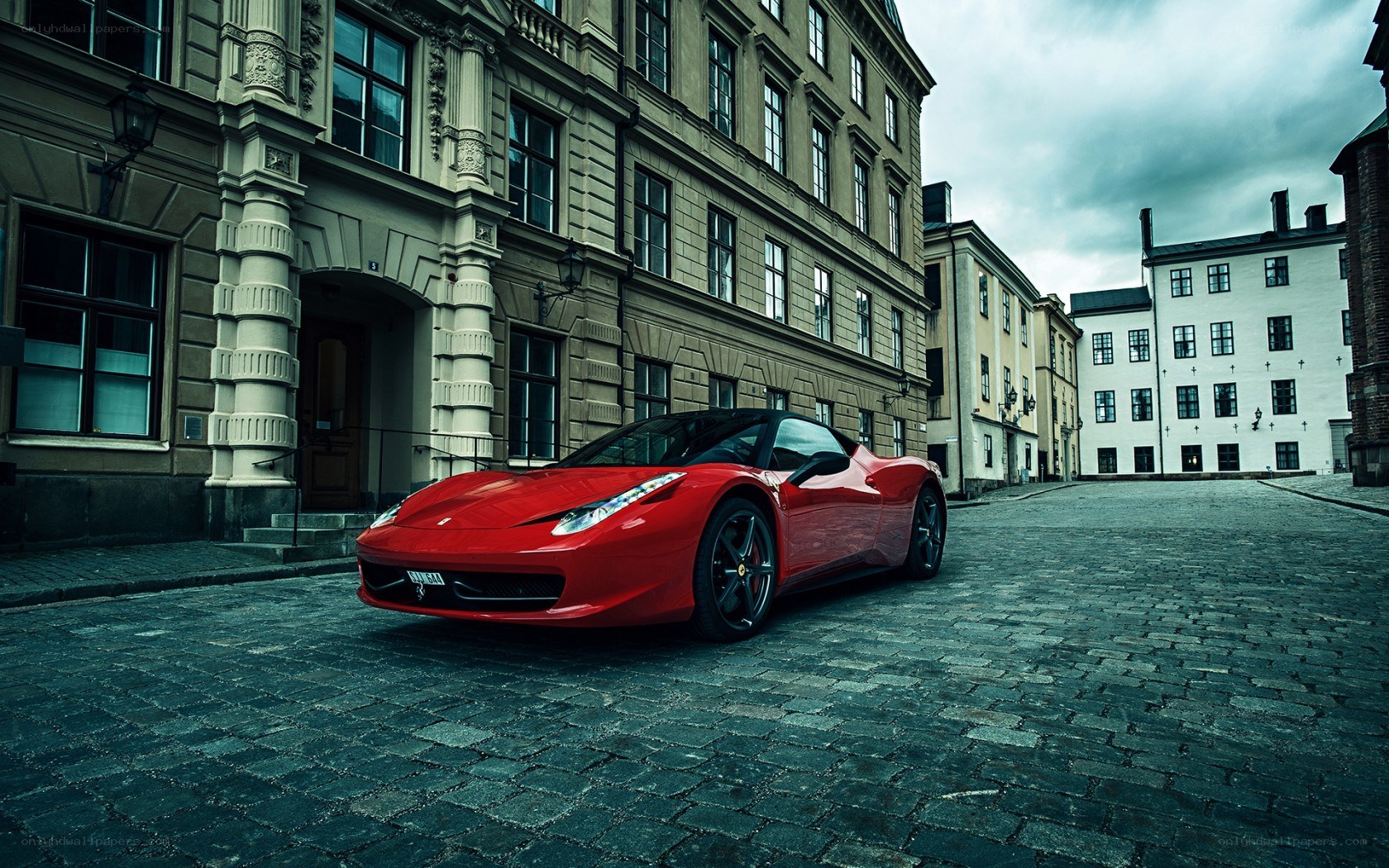 Red Ferrari on cobblestone street