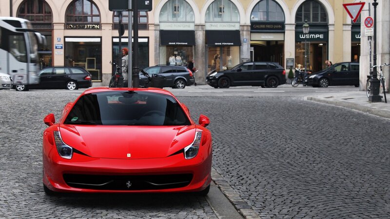 Red Ferrari on cobblestone street