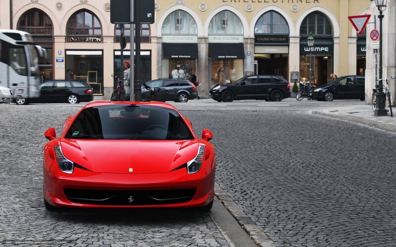 Red Ferrari on cobblestone street