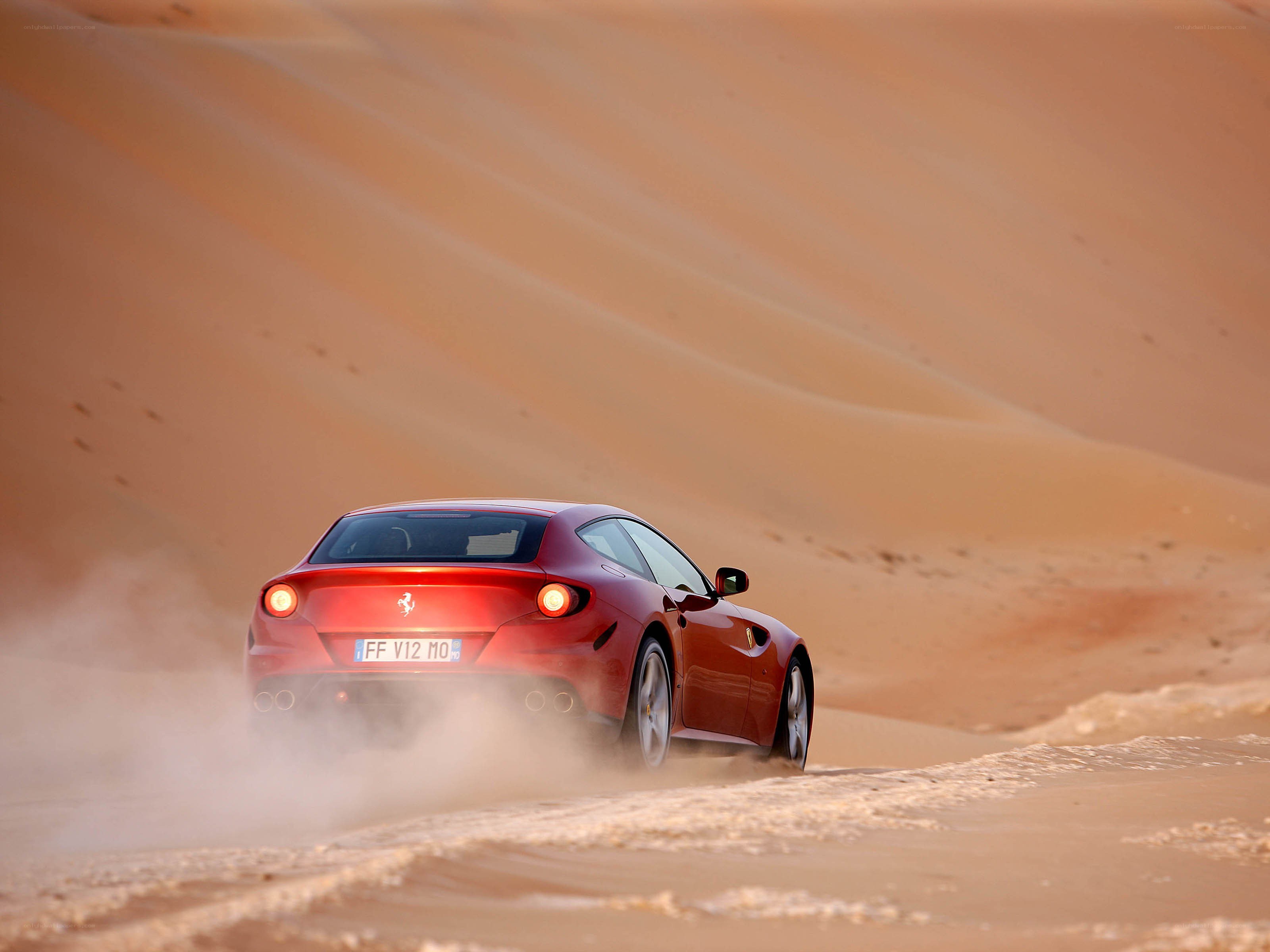 Red Ferrari on desert dunes