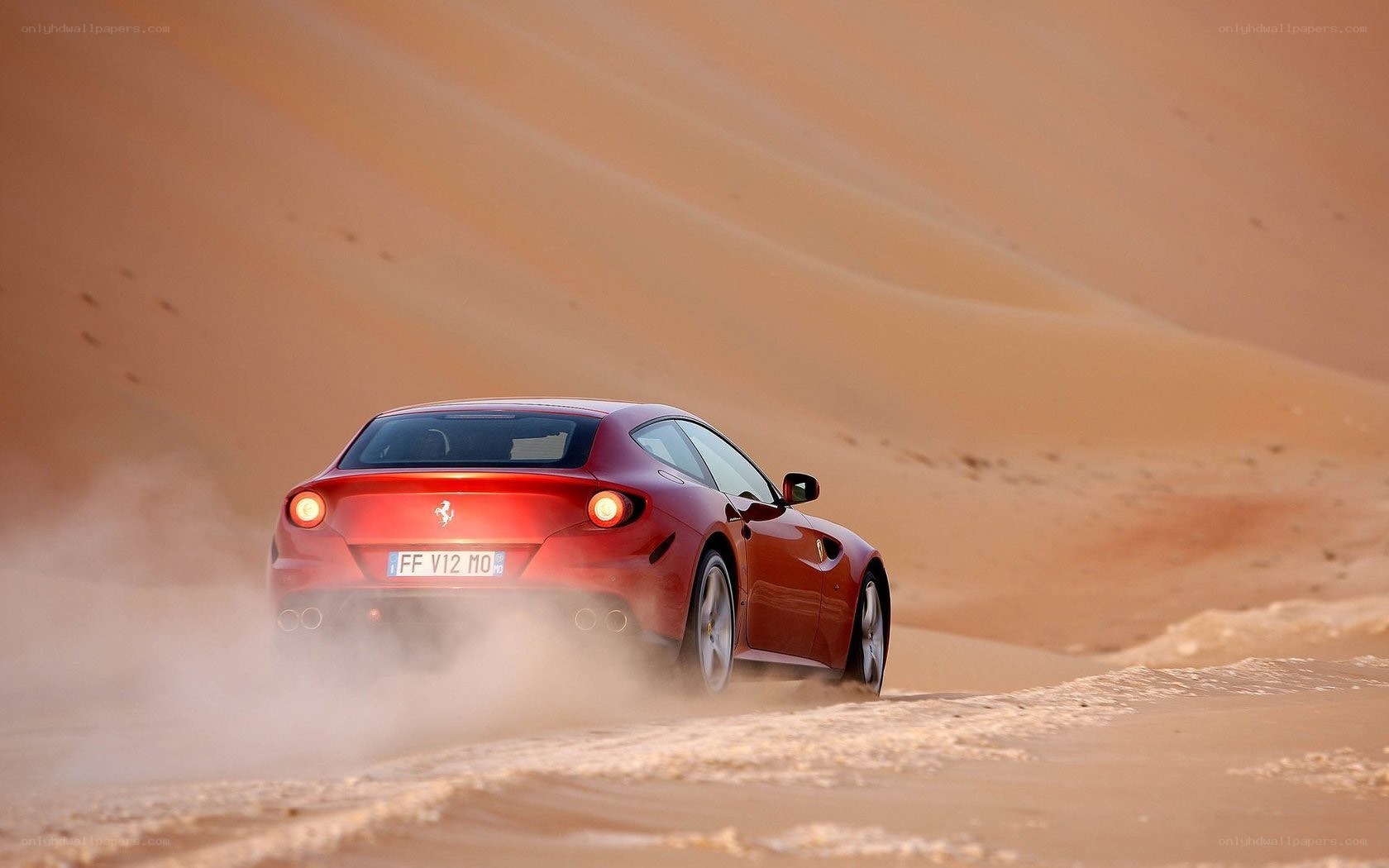 Red Ferrari on desert dunes