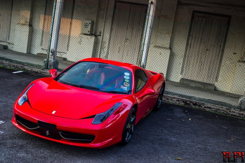 Red Ferrari parked in alley