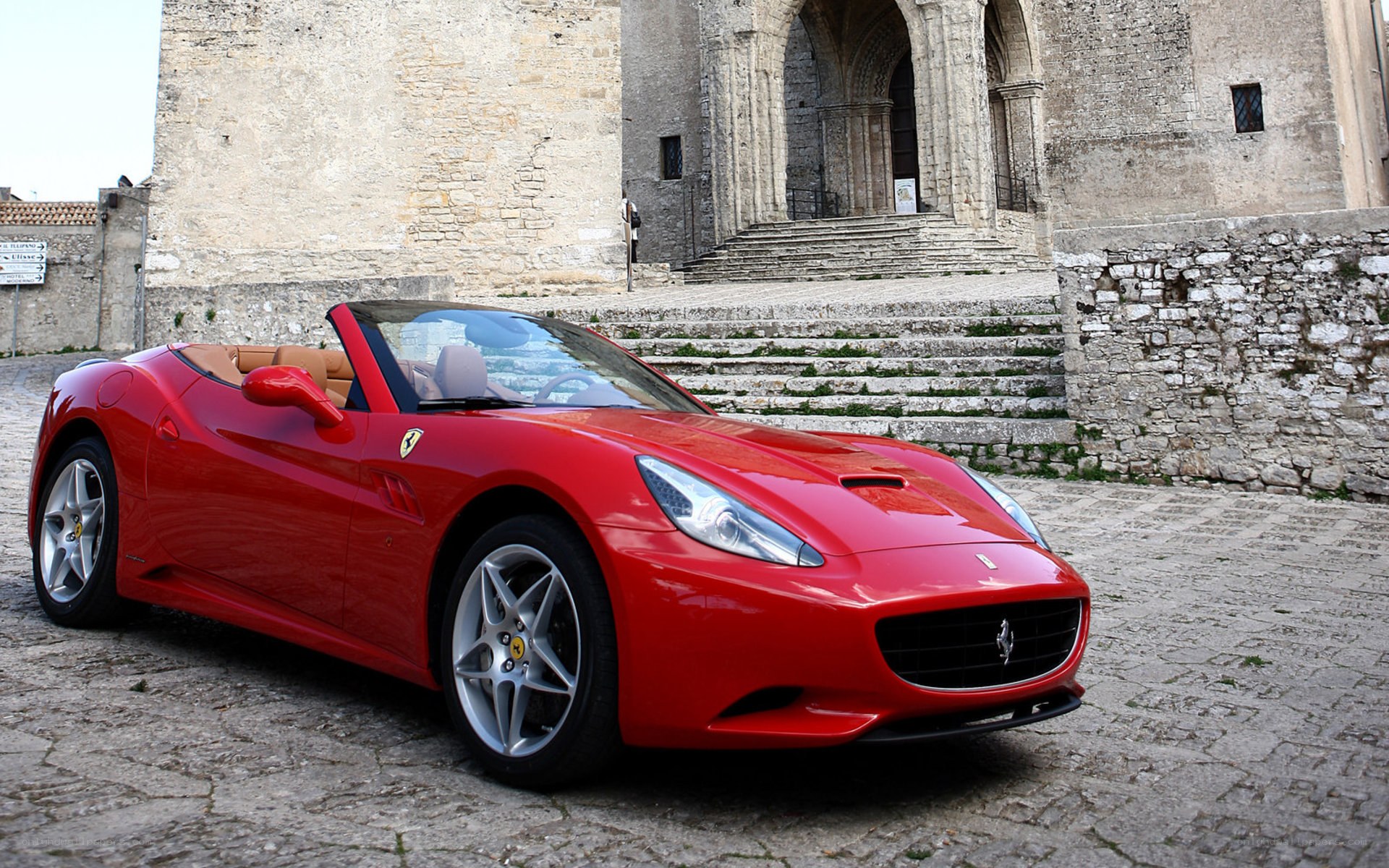 Red Ferrari parked in courtyard