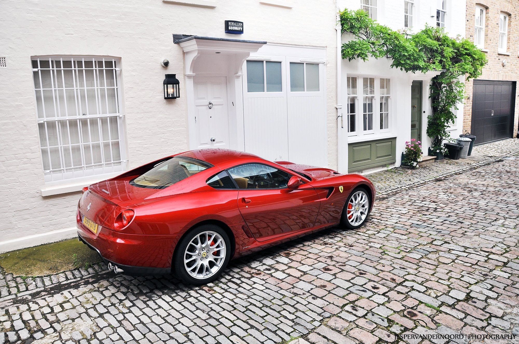 Red Ferrari parked on cobblestone