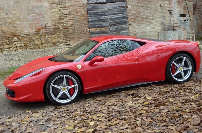 Red Ferrari parked on leaves