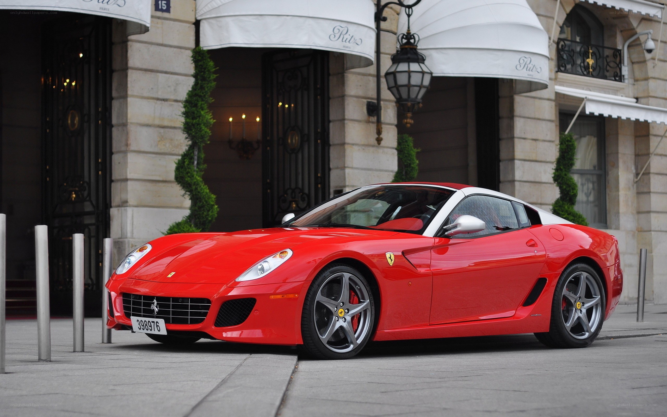 Red Ferrari parked outside hotel