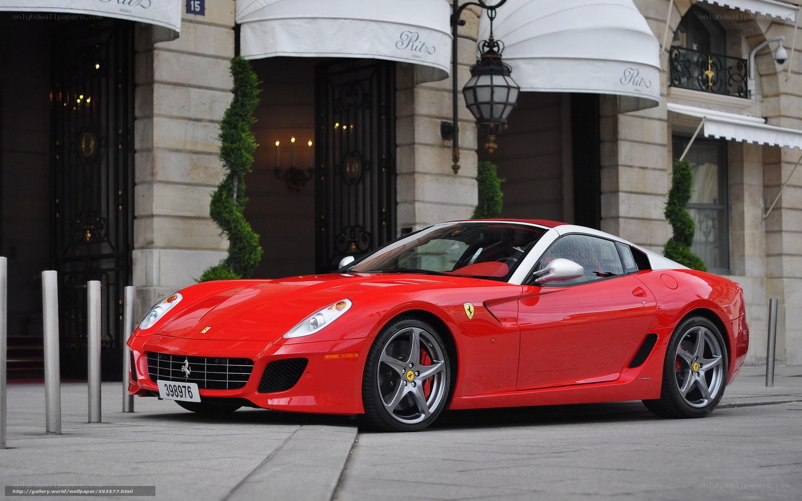 Red Ferrari parked outside hotel