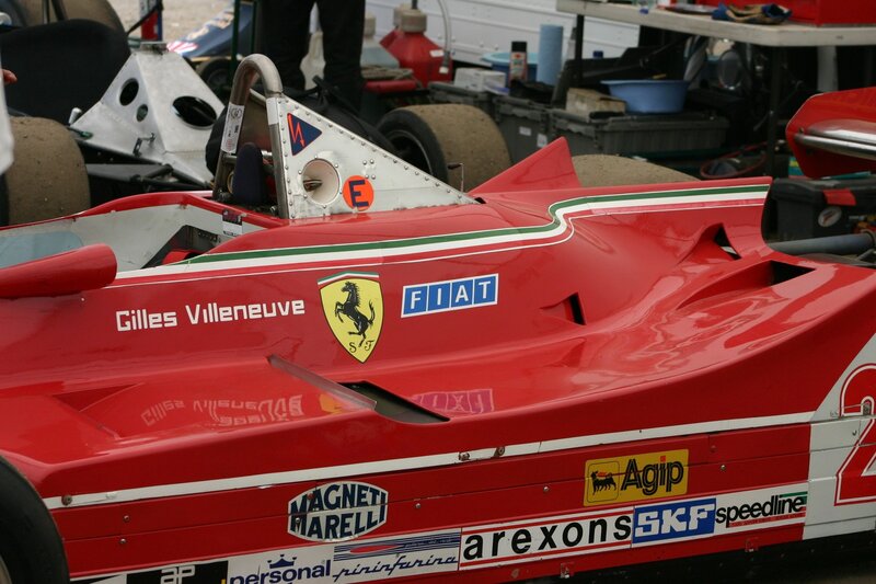 Red Ferrari race car in pit lane