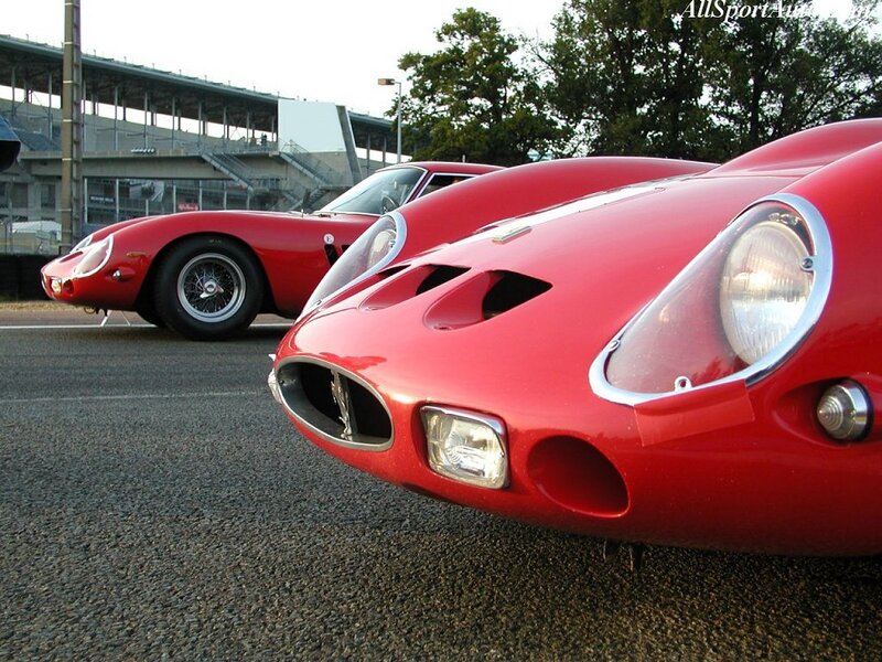 Red Ferrari race cars at a track