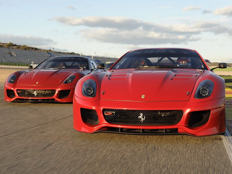 Red Ferrari race cars on track
