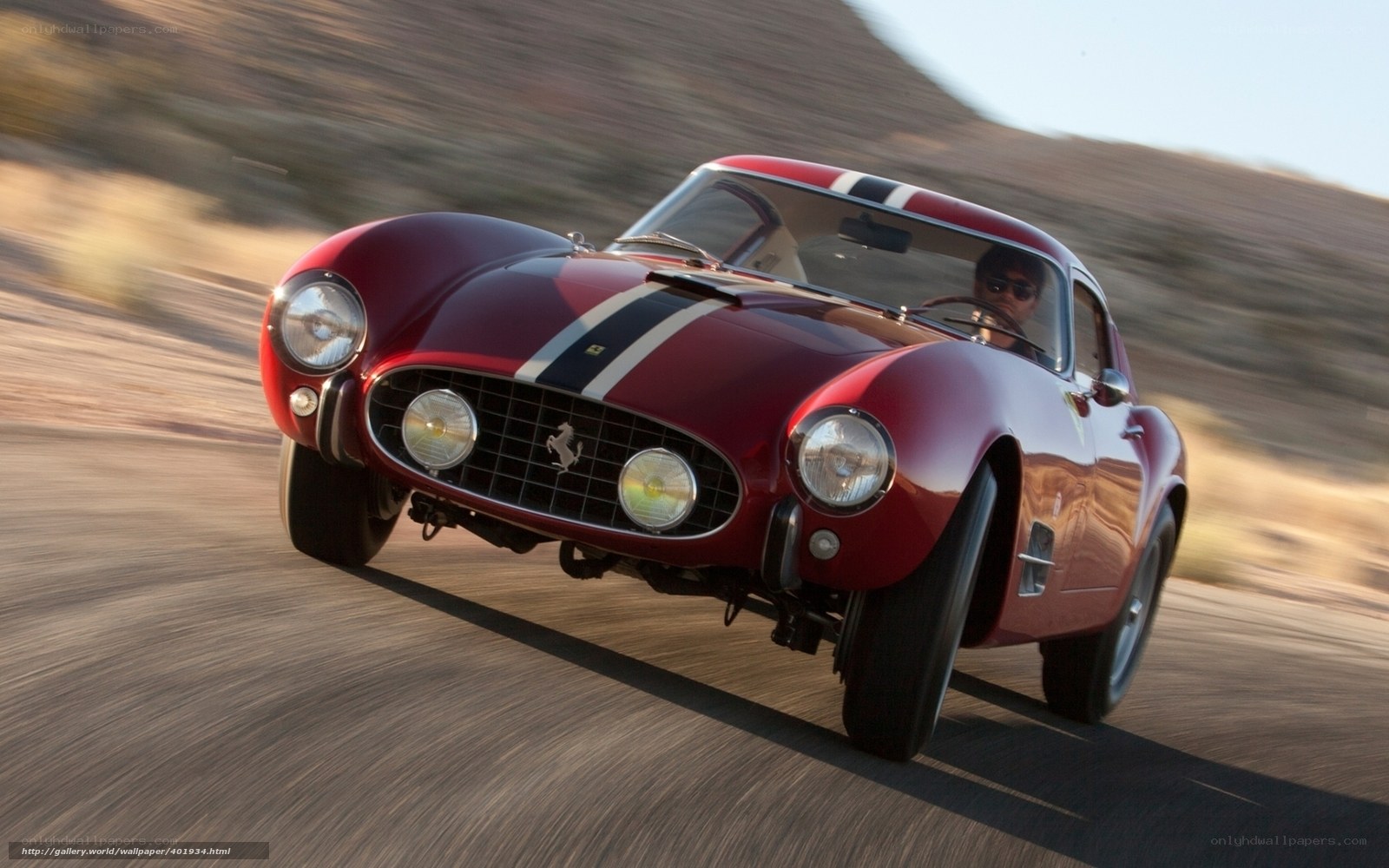 Red Ferrari racing on desert road