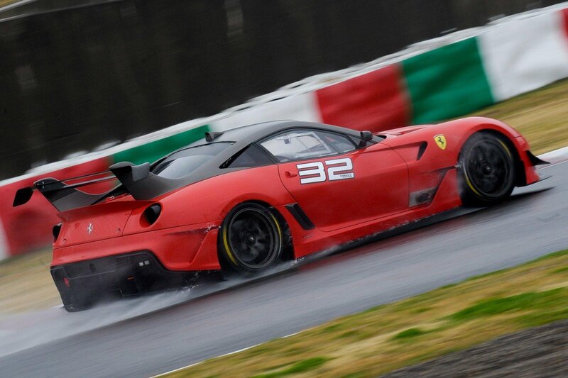 Red Ferrari racing on wet track