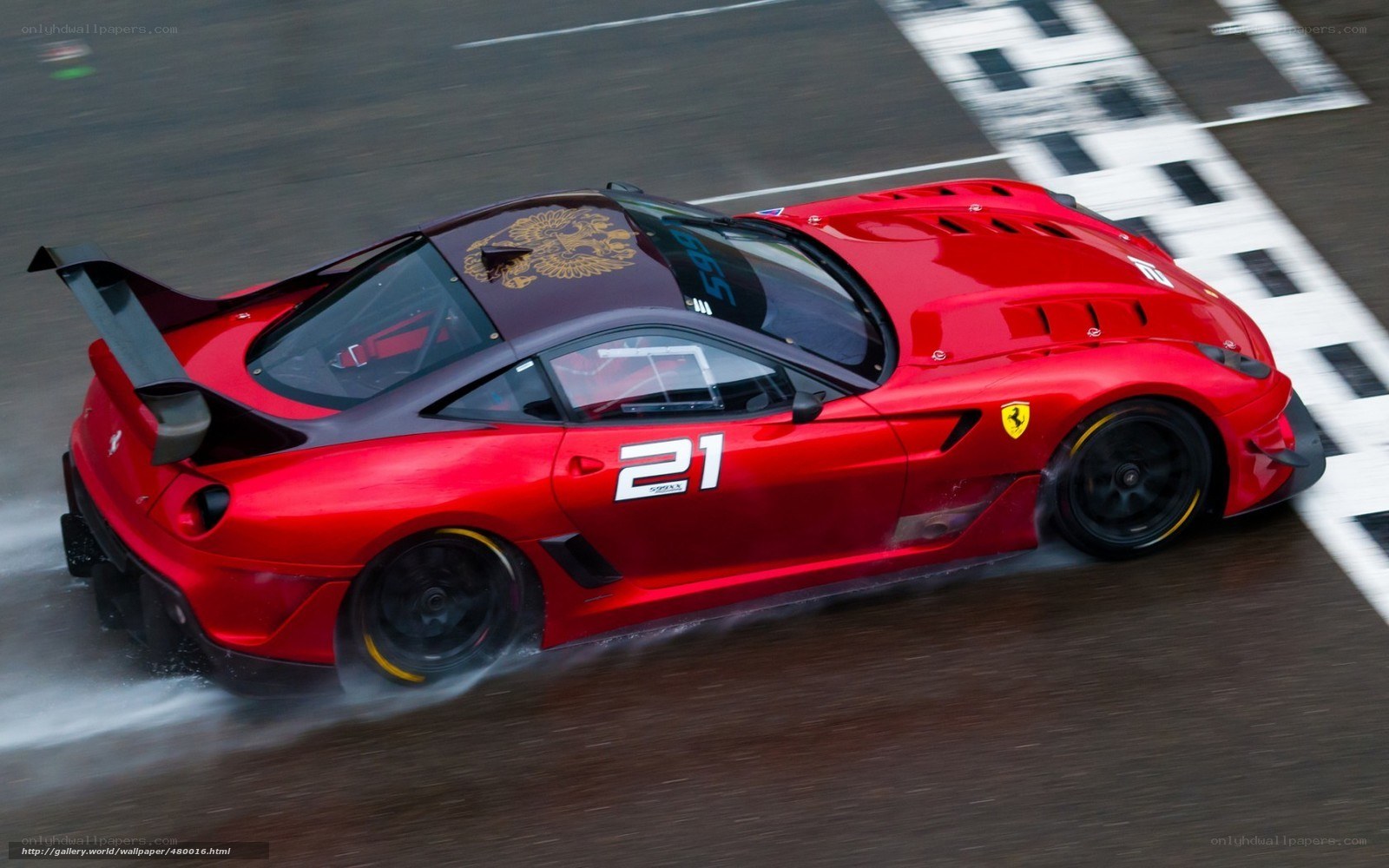Red Ferrari racing on wet track