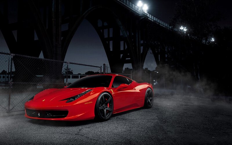 Red Ferrari under a bridge