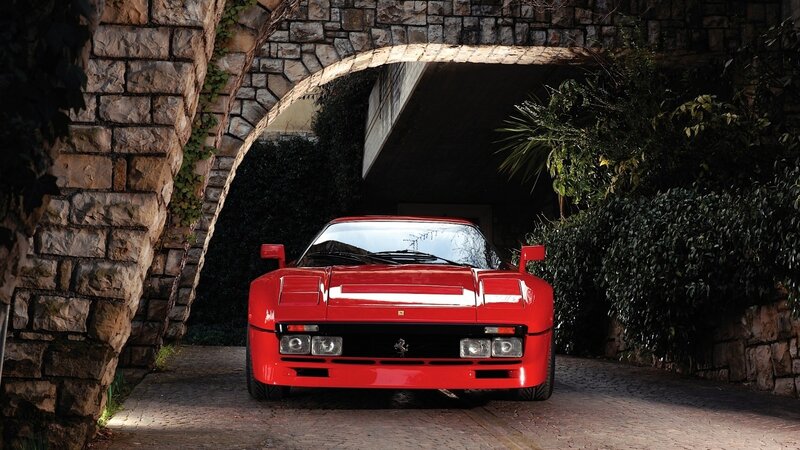 Red Ferrari under stone arch