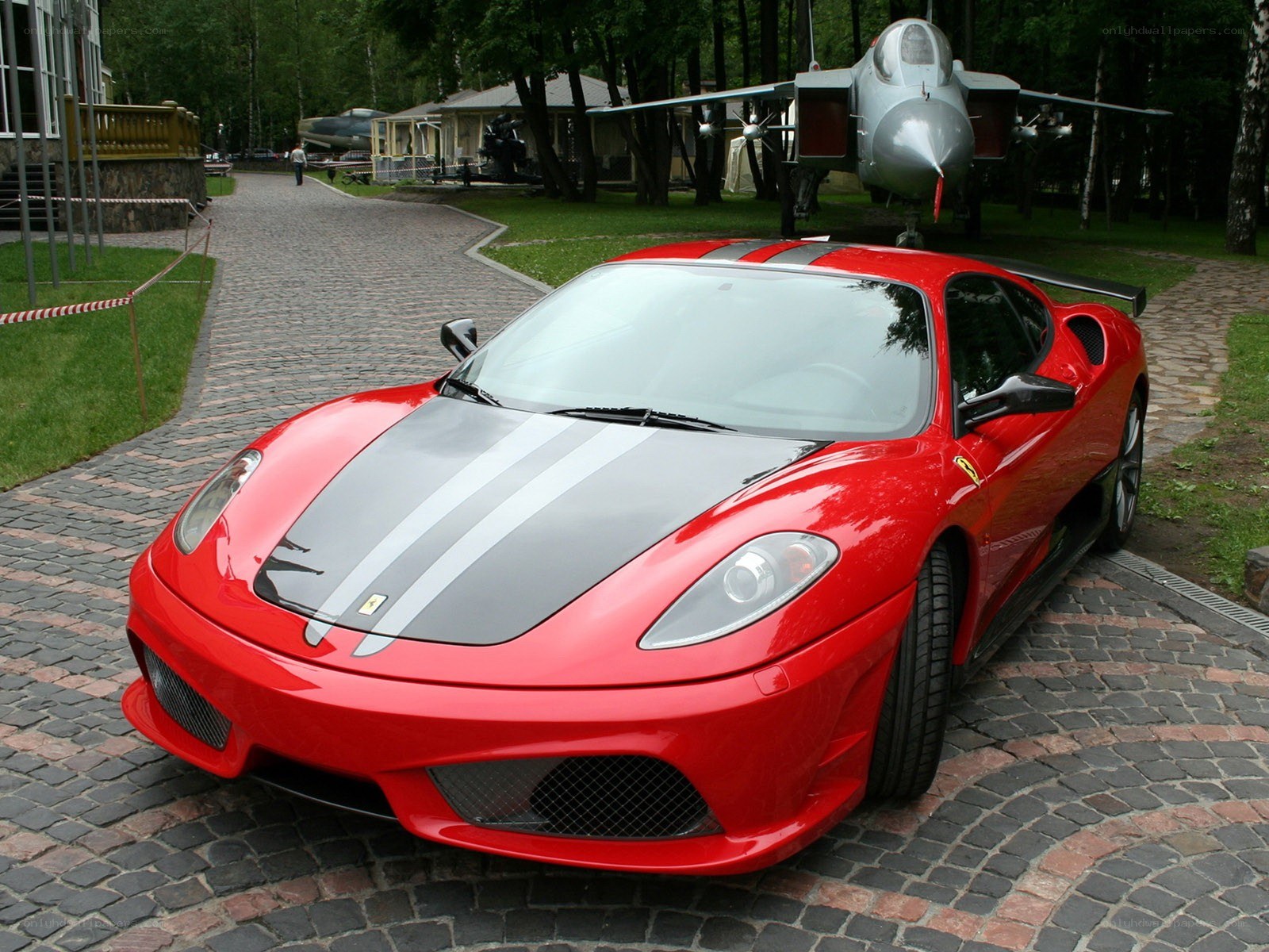 Red Ferrari with airplane in background