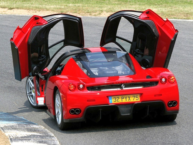 red ferrari with doors open