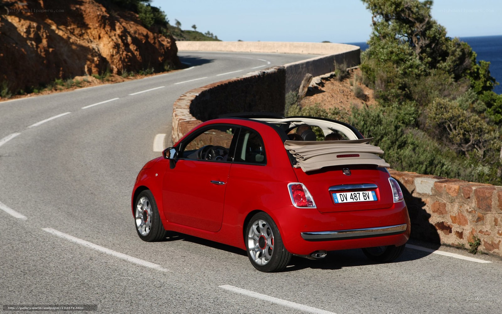 Red Fiat 500 Cabriolet on coastal road
