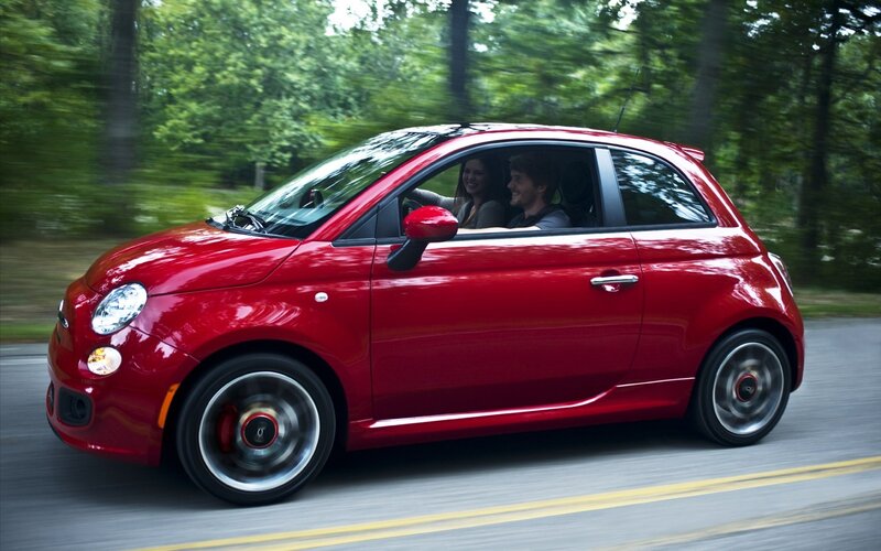 Red Fiat driving on a road
