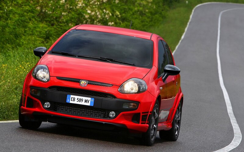Red Fiat Punto driving on road