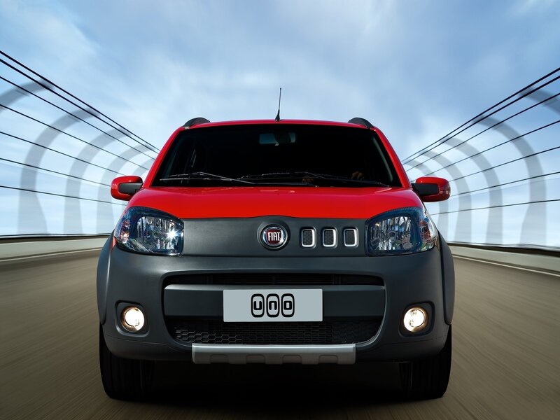 Red Fiat Uno driving on a bridge