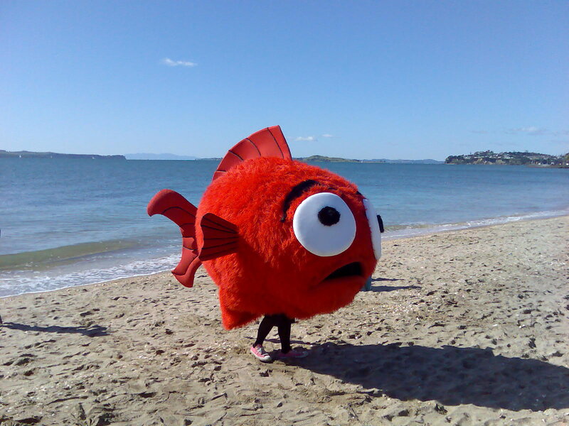 Red fish mascot on beach