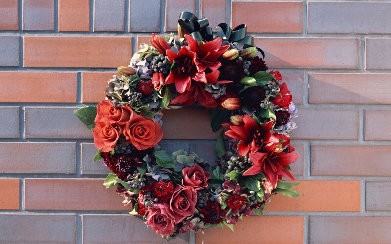 Red floral wreath on brick wall