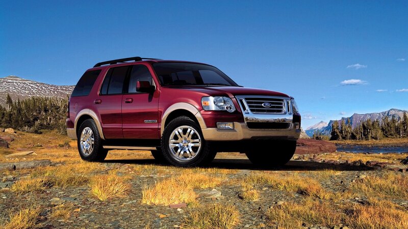 Red Ford Explorer in mountain landscape