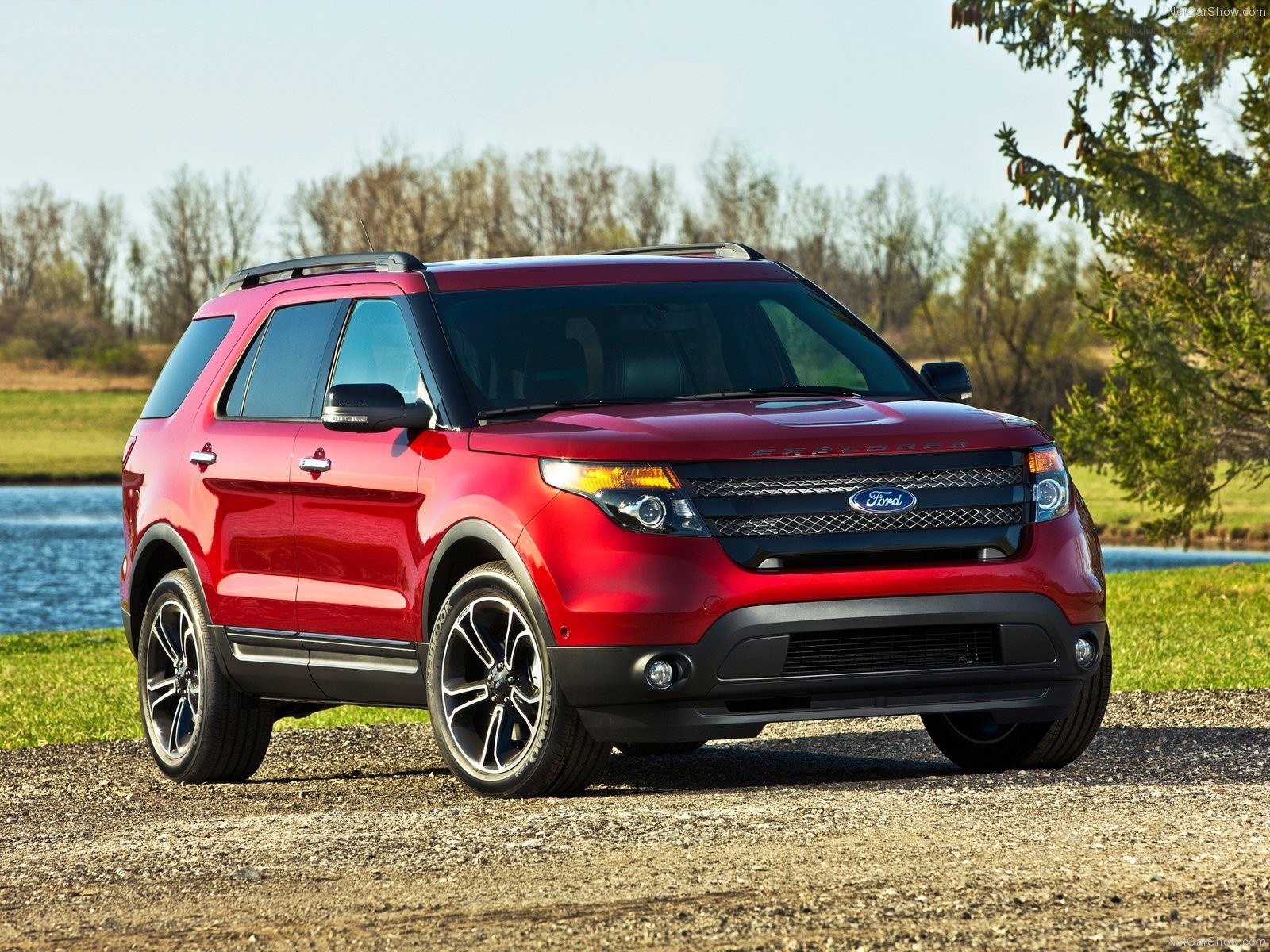 Red Ford Explorer parked by a lake